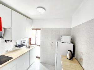 a white kitchen with a refrigerator and a sink at Casa de KanYan in Foz do Arelho