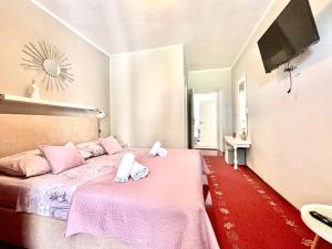 ツコンにあるApartments by the sea Tkon, Pasman - 24211のベッドルーム1室(ピンクベッド1台、タオル付)
