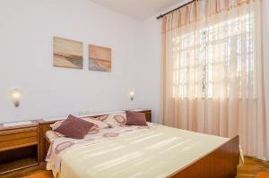 a bedroom with a large bed and a window at Apartments by the sea Orebic, Peljesac - 24372 in Orebić