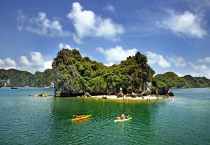 a group of people in boats in the water near a beach at Hung Long Harbour Hotel in Cat Ba