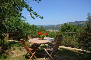a table with chairs and a vase with flowers on it at Monolocale in Radicondoli