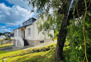 卡朗泰克MA ZI BIHAN Family home的一栋白色的房子，前面有一棵树