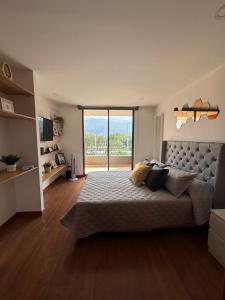 a bedroom with a large bed with a large window at Aparta estudio muy bien ubicado in Medellín