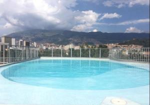 a large blue swimming pool on top of a building at Aparta estudio muy bien ubicado in Medellín