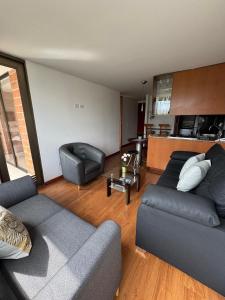 a living room with two couches and a kitchen at Aparta estudio muy bien ubicado in Medellín +19 photos