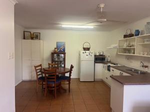 a kitchen with a table and a white refrigerator at Bongaree Getaway in Bongaree +5 photos