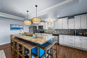 eine Küche mit weißen Schränken und eine Insel mit Barhockern in der Unterkunft Holiday Hideaway in Bolivar Peninsula