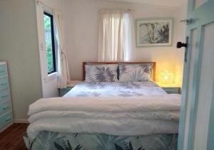 a bedroom with a bed and a window at Pipi Palace in Papamoa