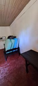 a room with a bed and a table in it at Chácara gratidão a Deus in Morretes