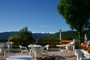 d'une terrasse avec des tables et des chaises blanches et une vue sur les montagnes. dans l'établissement Hotel Al Poggio, à Sestola