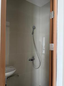 a bathroom with a shower and a sink at Kostaycation Front Of Kampus Esa Unggul Tangerang in Ciapus