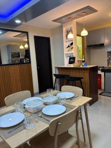 einen Holztisch mit Tellern und Gläsern darauf in der Küche in der Unterkunft Home 24 Transient in Sampong