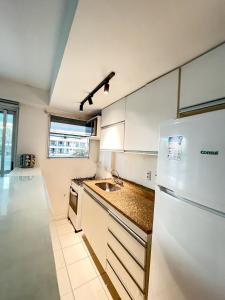 una cucina con un frigorifero bianco e un lavello di Resort na Praia do Recreio a Rio de Janeiro Altre 44 foto