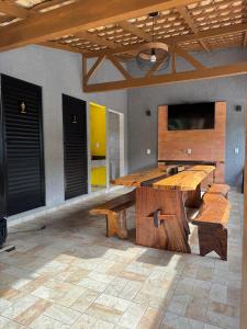 Habitación con mesas de madera y TV de pantalla plana. en Chácara do Paulo, en Santo Amaro da Imperatriz