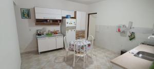a small kitchen with a table and a refrigerator at Refúgio em São Paulo in São Paulo