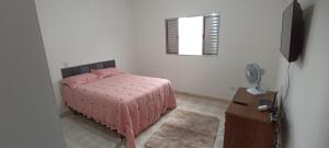 a bedroom with a pink bed and a window at Refúgio em São Paulo in Sao Paulo