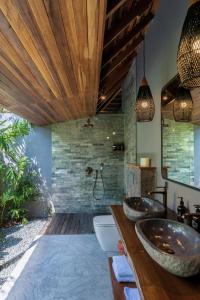 ウルワツにあるMona Boutique Villas & Spaのバスルーム(木製カウンターのシンク2つ付)