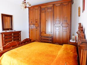 a bedroom with a large bed and wooden cabinets at Casa Anni '70 in Burgos