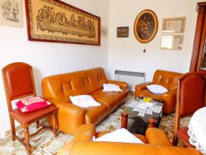 a living room with leather furniture and a couch at Casa Anni '70 in Burgos