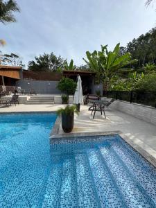 - Piscina con mesa y sombrilla en Chácara do Paulo, en Santo Amaro da Imperatriz