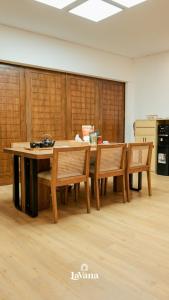 a table and chairs in a room with wooden walls at Lavana Villa by Raminten in Yogyakarta