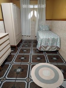 Mały pokój z łóżkiem i podłogą wyłożoną kafelkami w obiekcie Casa em frente ao maior são João do mundo w mieście Campina Grande