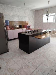 kuchnia z czarną wyspą w pokoju w obiekcie Casa em frente ao maior são João do mundo w mieście Campina Grande