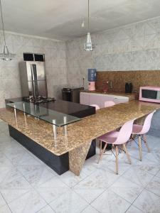 kuchnia z dużym blatem z różowymi krzesłami w obiekcie Casa em frente ao maior são João do mundo w mieście Campina Grande +7 zdjęć