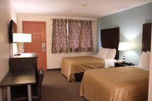 a hotel room with two beds and a window at Sterling Inn near IAG Airport in Niagara Falls