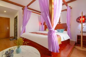 Un dormitorio con dos camas con cortinas moradas. en Zhangjiajie Xinghe Qingmeng Inn offers free shuttle service to the vicinity of the east gate of the National Forest Park, advance purchase of scenic spot tickets, free laundry service, and freshly ground coffee, en Zhangjiajie