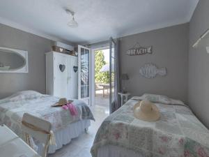 a bedroom with two beds and a door to a patio at Luxury Villa with Jacuzzi in Les Issambres in Les Issambres