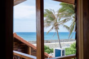 a room with a view of the ocean and a palm tree at The Happy House Phú Quý - Kailash in Cu Lao Thu