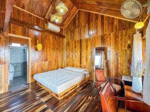 a bedroom with a bed in a wooden wall at The Happy House Phú Quý - Kailash in Cu Lao Thu