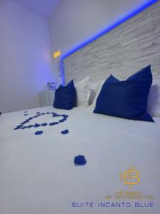 a bedroom with a white bed with blue pillows at Mé Besito in Ari