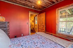 a bedroom with red walls and a bed in it at Historic Cabin with Porch and Firepit 5 Minutes from Bryson City in Bryson City