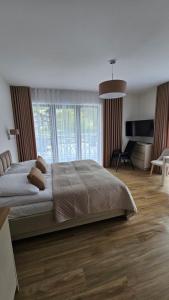 ein Schlafzimmer mit großem Bett und ein Wohnzimmer in der Unterkunft Willa Zacisze Szczawnica Apart in Szczawnica + 24 Fotos