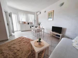 a living room with a couch and a tv at Apartmani Stine in Okrug Donji