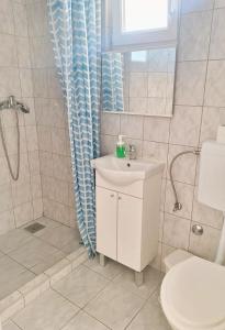 a bathroom with a sink and a shower and a toilet at Apartmani Stine in Okrug Donji