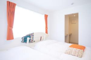 two beds in a bedroom with a window at Z LAND Enoshima by Tranova in Fujisawa
