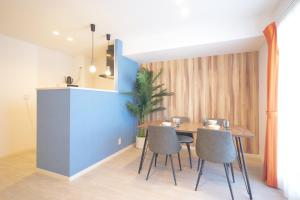 a dining room with a blue wall and a table and chairs at Z LAND Enoshima by Tranova in Fujisawa +188 photos