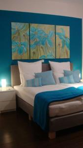 a bedroom with a large bed with a blue wall at Hotel Flower Power in Hehlen