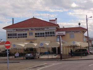 um edifício numa rua com carros estacionados em frente em Residencial as Canárias em Ponte de Sor