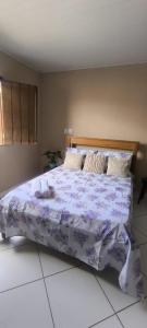 1 dormitorio con 1 cama grande y edredón morado en Casa LV, en Lençóis