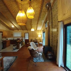 a living room with two lights hanging from the ceiling at Cabaña a orilla del río Liucura in Pucón