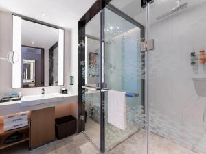 un bagno con doccia in vetro e lavandino di Hampton by Hilton Guangzhou Jinshazhou a Canton