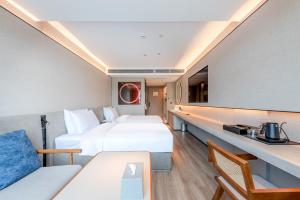 A bed or beds in a room at 深圳宝安国际会展中心桔子水晶酒店
