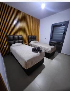 a bedroom with two beds and a television in it at Appartement luxe marchica med atalayoun in Nador