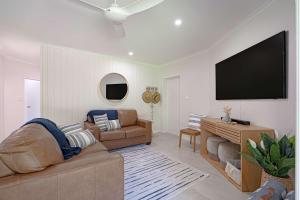 a living room with a couch and a flat screen tv at Liana One Coastal Mission Vibe One Bedroom in Mission Beach