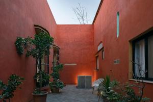 a red building with plants on the side of it at Solazul Experiencia & Estancia in Puebla