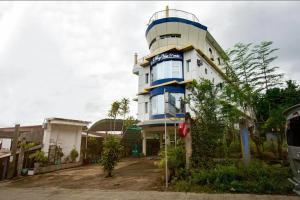 a building with a blue and white at Dads Bayview Pension in Puerto Princesa City